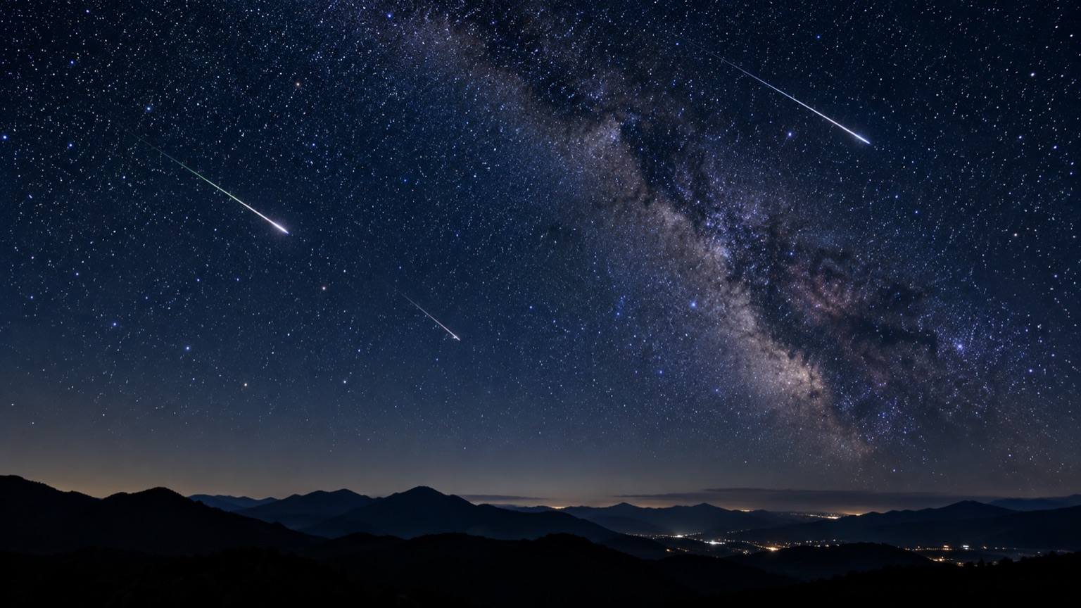 秋の夜空に流れる流れ星と山並みのシルエット(イメージ)