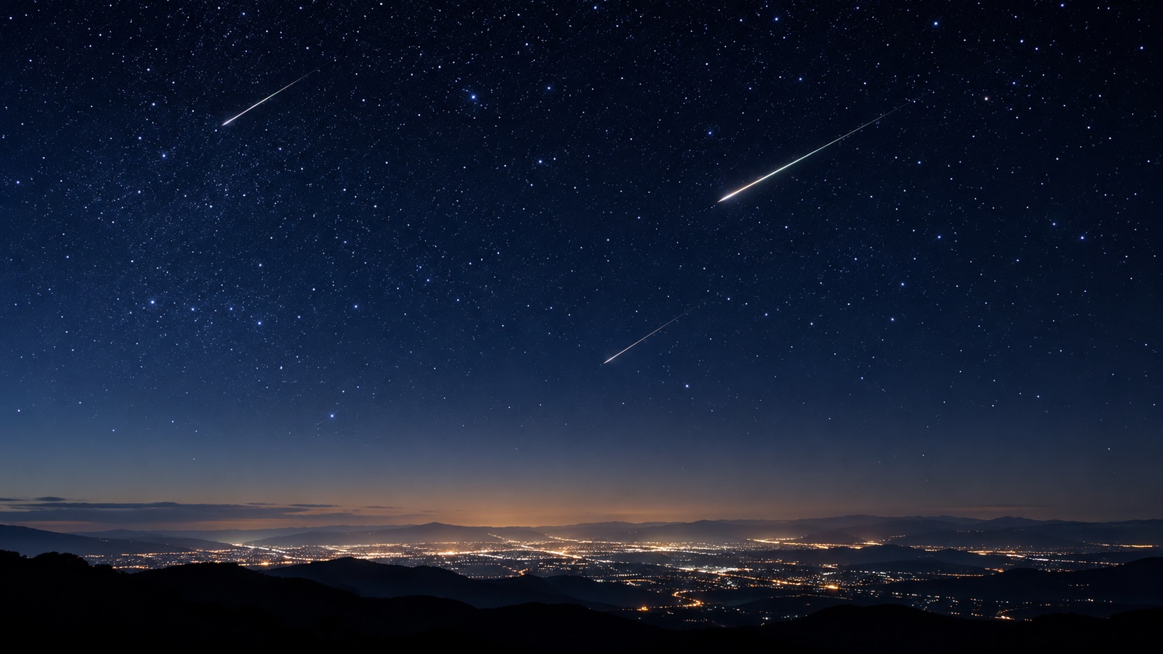 秋の夜空に流れる流れ星と街明かり(イメージ)